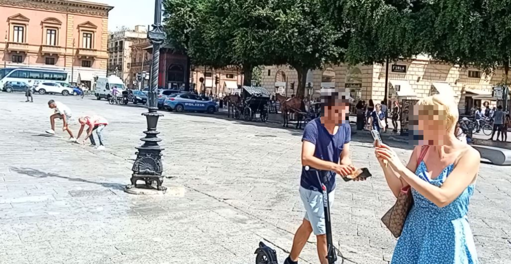 Uomo butta soldi a terra, piazza Verdi