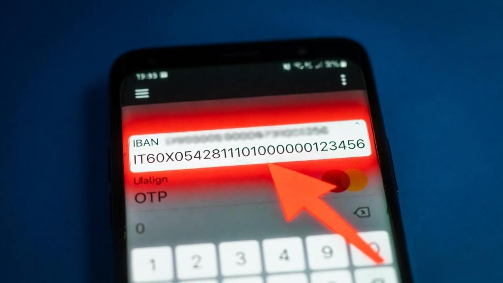 Schema visivo della truffa IBAN Swap con smartphone, bonifico bancario e punto critico sull’OTP