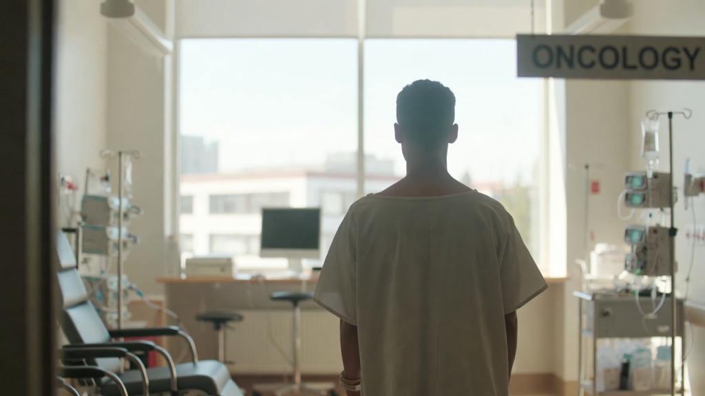 Giovane paziente in reparto di oncologia durante controlli preventivi