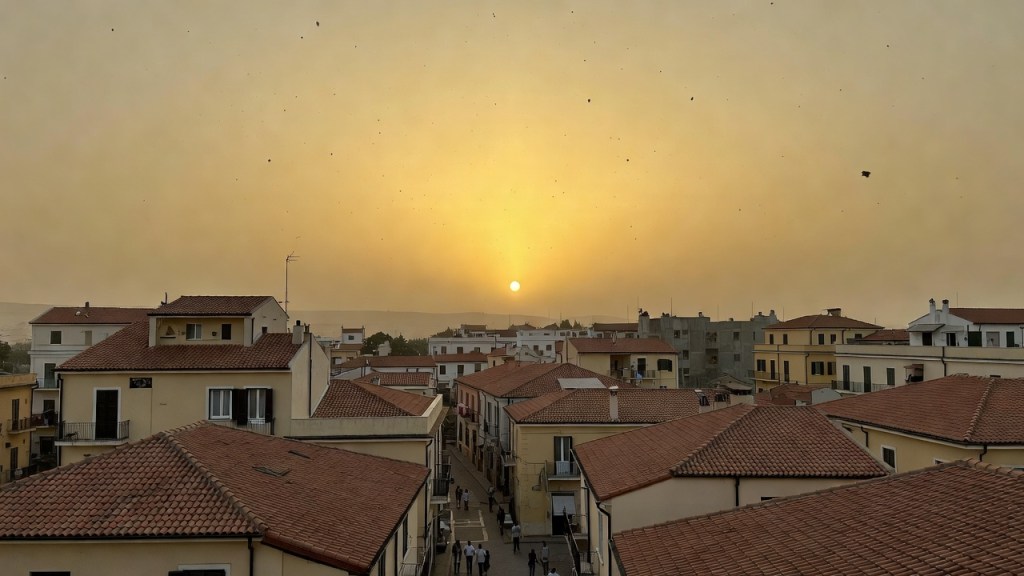 Cielo velato giallognolo su città italiana per sabbia sahariana