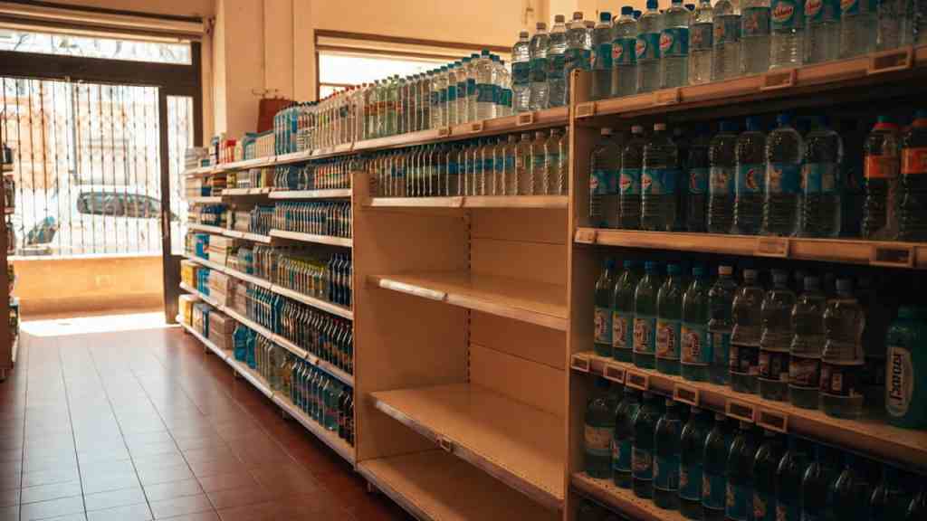 Scaffale di supermercato con bottiglie d'acqua minerale in plastica