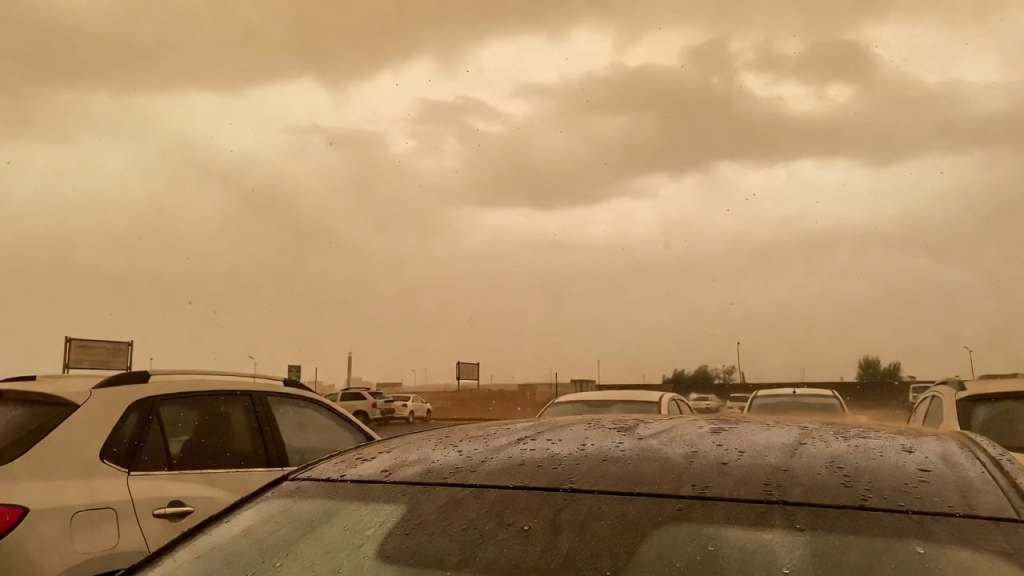 Auto sporche di sabbia sahariana sotto la pioggia con cielo coperto in Italia