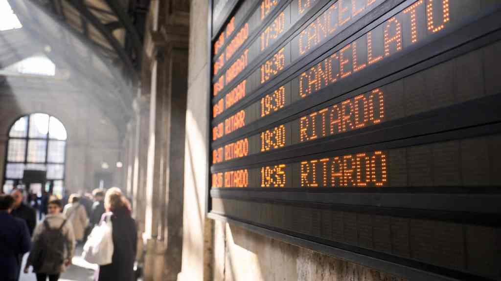 Tabellone ferroviario con treni cancellati in una stazione italiana, guida al rimborso per sciopero 2026