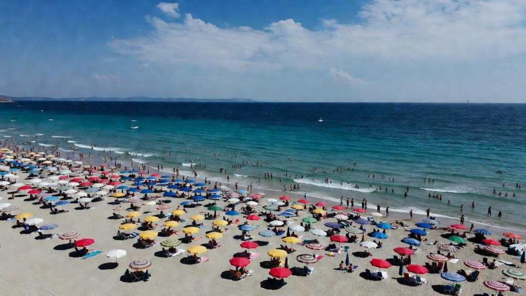 Spiaggia italiana affollata in estate, tema divieti e sanzioni