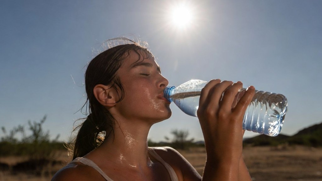 Donna che beve per il caldo