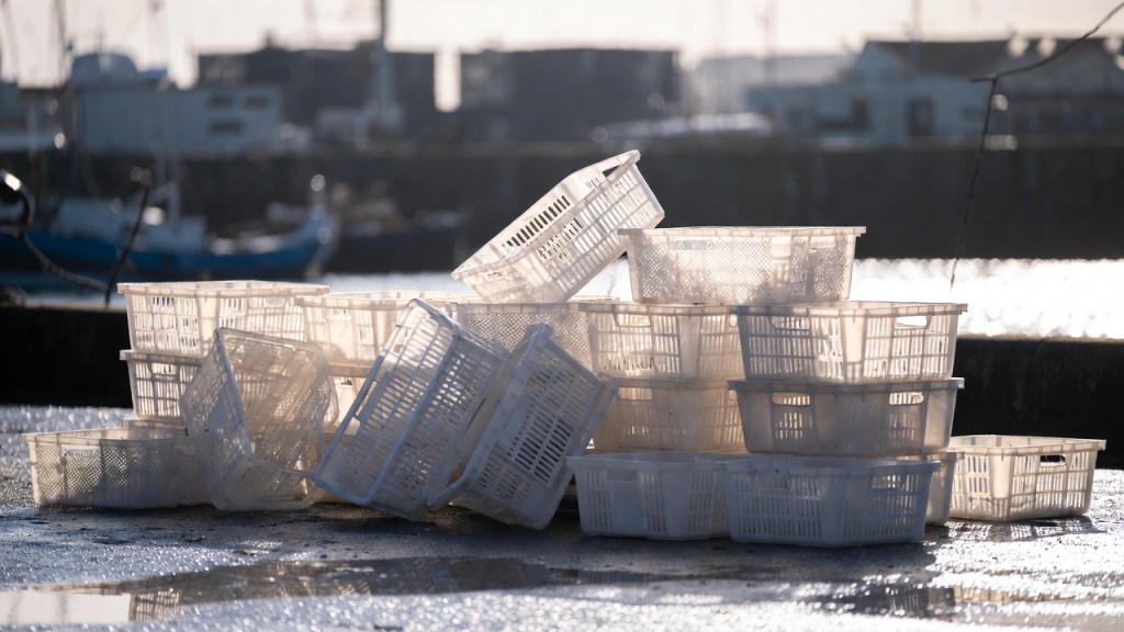 Cassette per il pesce impilate su una banchina portuale