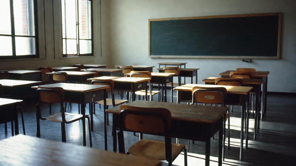 Aula scolastica vuota con banchi allineati, riferimento ai dati sull'abbandono scolastico precoce in Sicilia
