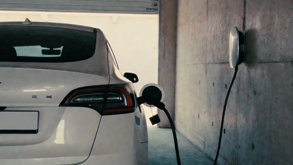 Auto elettrica in ricarica in un garage privato con wallbox a parete, riferimento al bonus colonnine domestiche