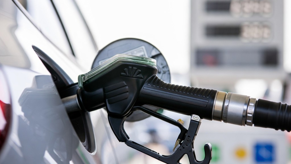 Rifornimento di carburante a un distributore self service con display dei prezzi sfocato