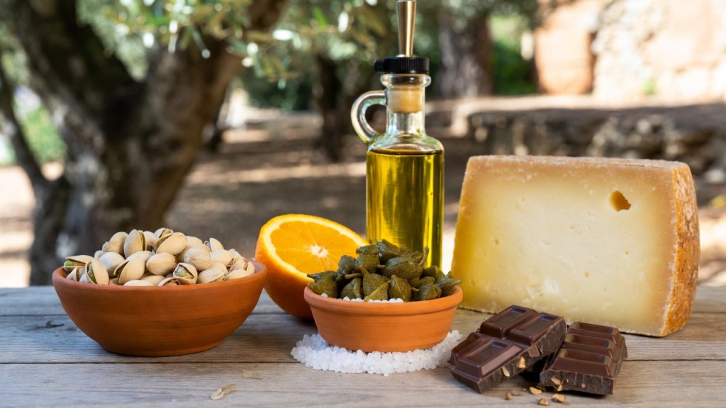 Arance rosse, pistacchi, formaggio, olio, capperi e cioccolato su un tavolo di legno, per l’elenco dei prodotti DOP e IGP della Sicilia