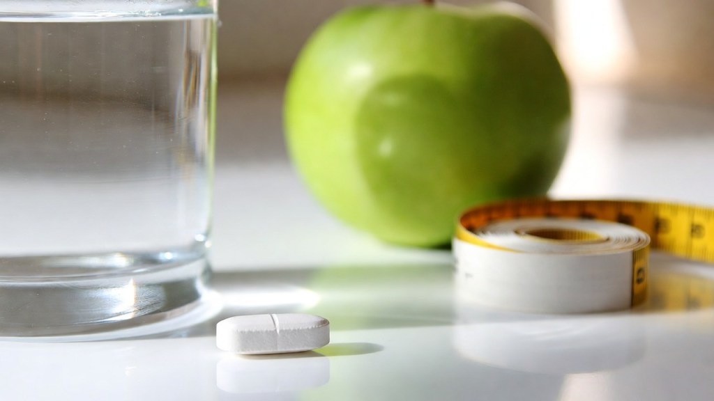 Compressa bianca con un bicchiere d’acqua, un metro da sarta e una mela, per l’articolo sulla semaglutide orale contro l’obesità